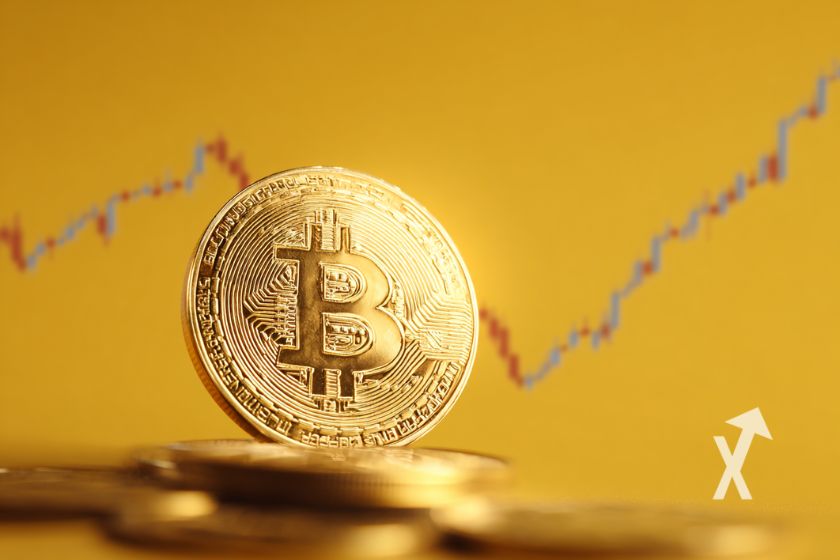 Coin Bitcoin sur un fond jaune avec une trendline de bougies rouges et vertes en fond
