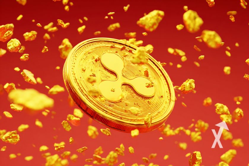 coin XRP en jaune sur un fond rouge avec des particules d'or qui volent