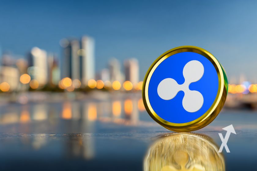 Jeton XRP Ripple posé devant la vile d'abu dhabi en fond