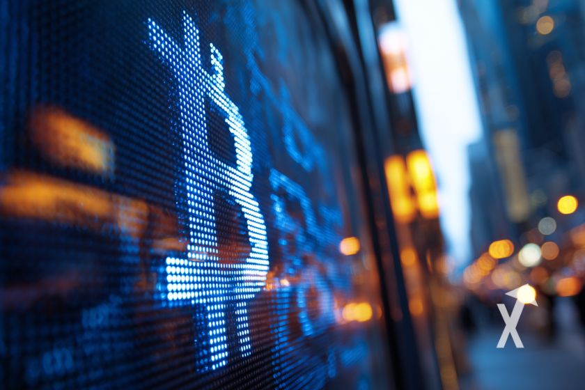 Bitcoin logo en bleu sur un panneau de wall street