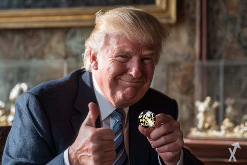 donald trump tout sourire montrant son memecoin le pouce levé