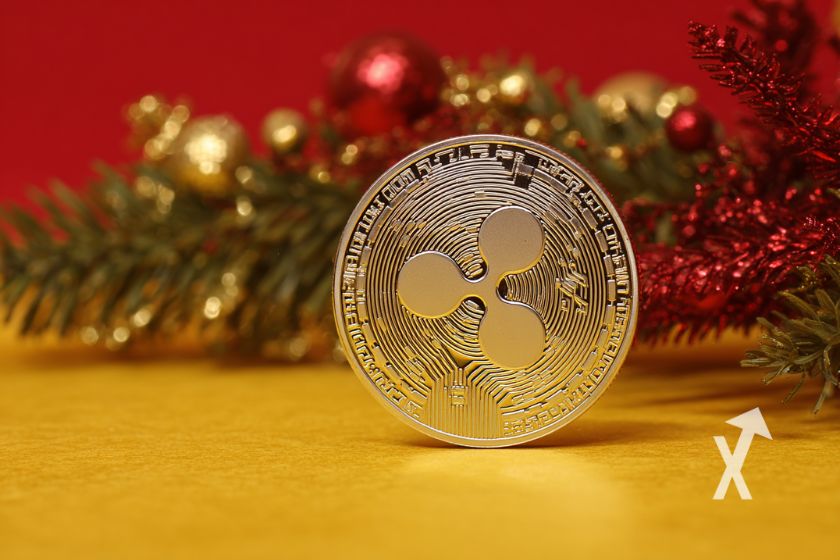 coin xrp sur un fond rouge et jaune avec une barche de sapin de noël en fond