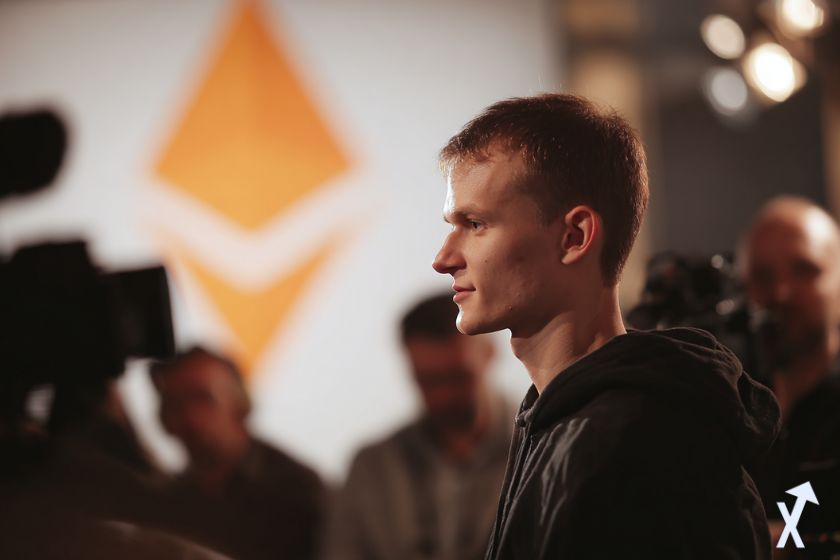 vitalik buterin fondateur d'ethereum lors d'une conférence de presse, logo ethereum orange en fond