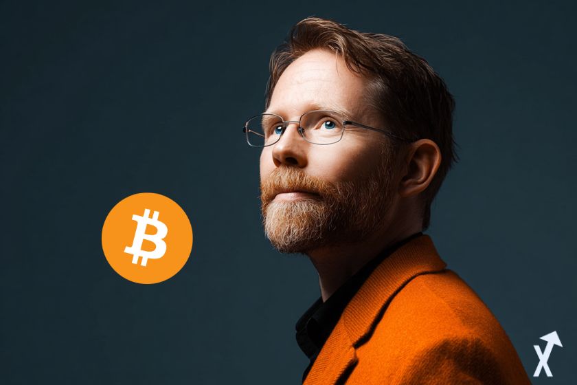 eric larcheveque en costume, regard lointain et logo bitcoin