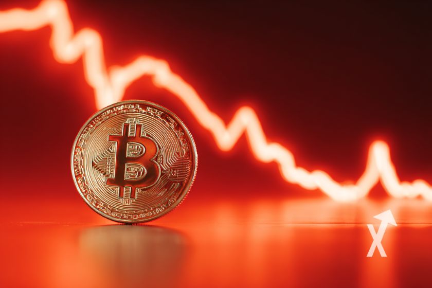 Bitcoin coin sur un fond rouge avec une trendline baissière rouge