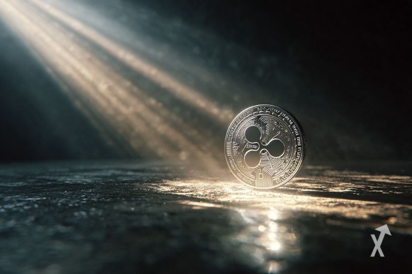 Une pièce en argent avec le logo XRP exposée à la lumière dans un endroit sombre
