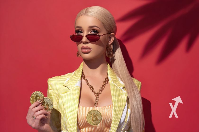Iggy Azalea sur fond rouge avec un bitcoin dans la main