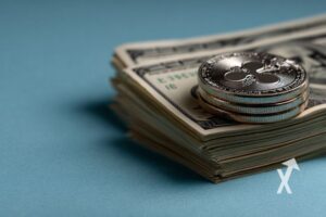coin xrp sur une liasse de billets avec fond bleu